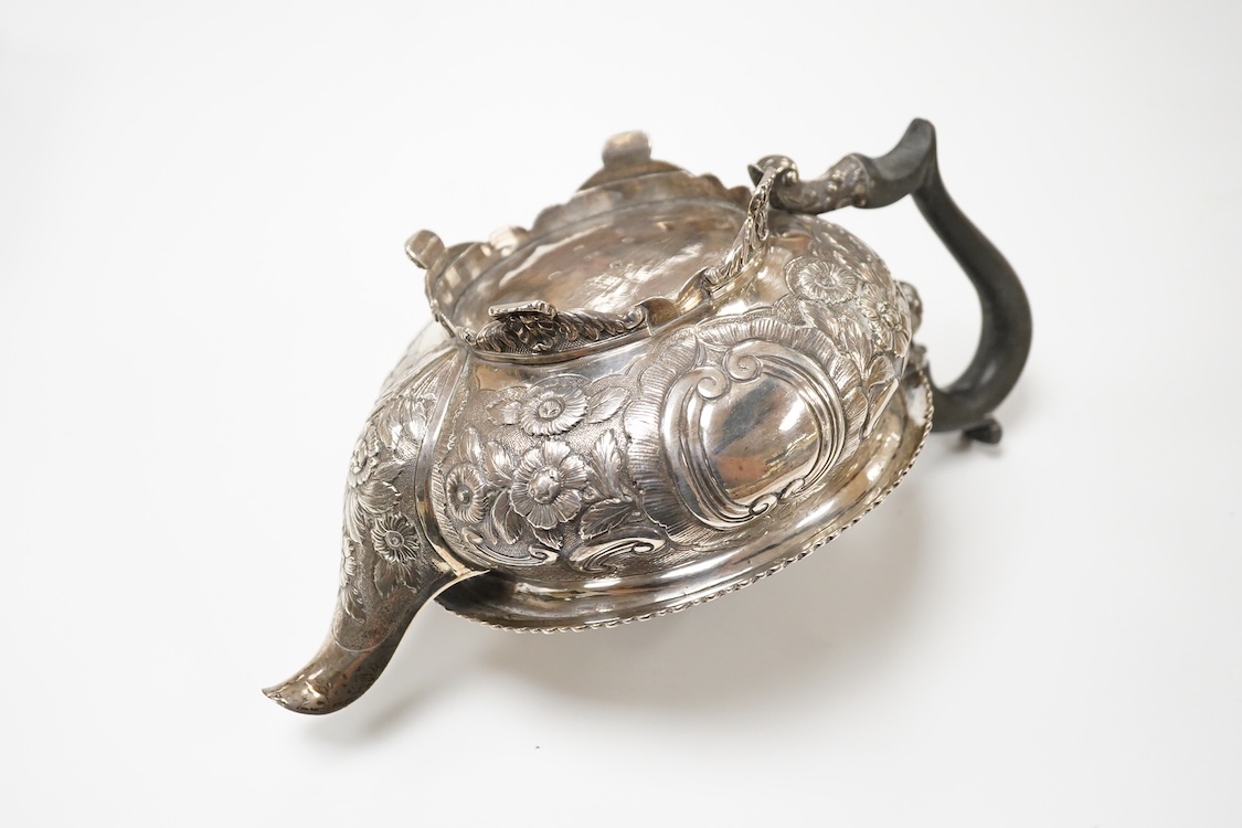 A late George III silver circular teapot, by Samuel Hennell, London, 1818, with later embossed decoration, gross weight 26.9oz.